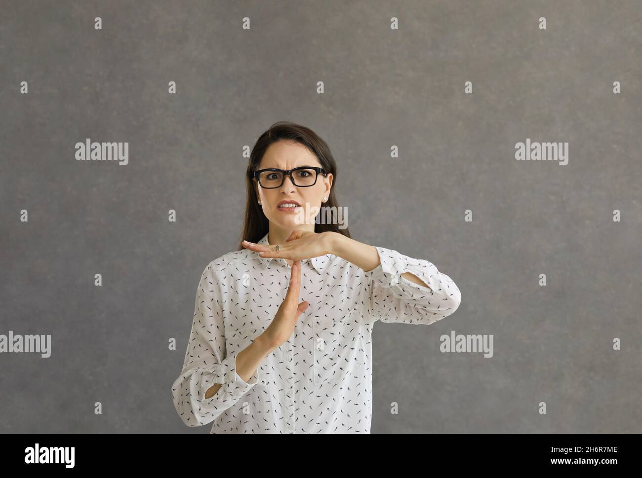 Eine verärgerte junge Frau, die Sie bittet, aufzuhören und eine Geste mit einer Auszeit-Zeichen-Hand zu tun Stockfoto