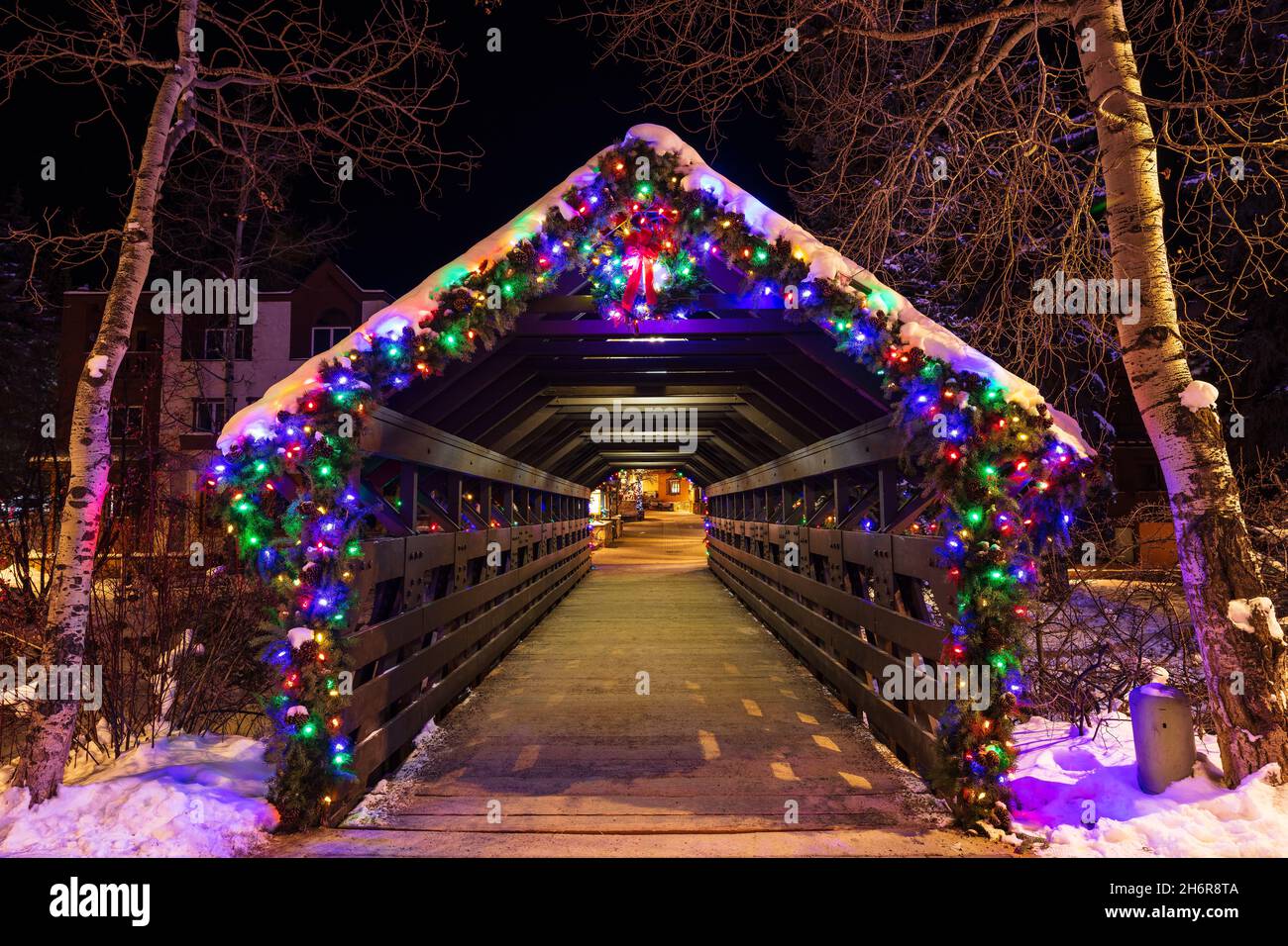 Winterszene mit Weihnachtslichtern auf der überdachten Brücke von Gore Creek in Vail Village, Colorado, USA Stockfoto