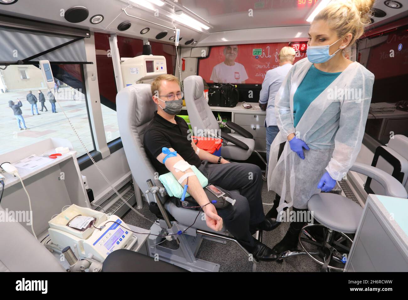 Krakau. Krakau. Polen. Der Mann spendet Blut in einer mobilen Blutspendeeinheit, die eine Maske trägt, aufgrund einer kovidalen Pandemie. Stockfoto