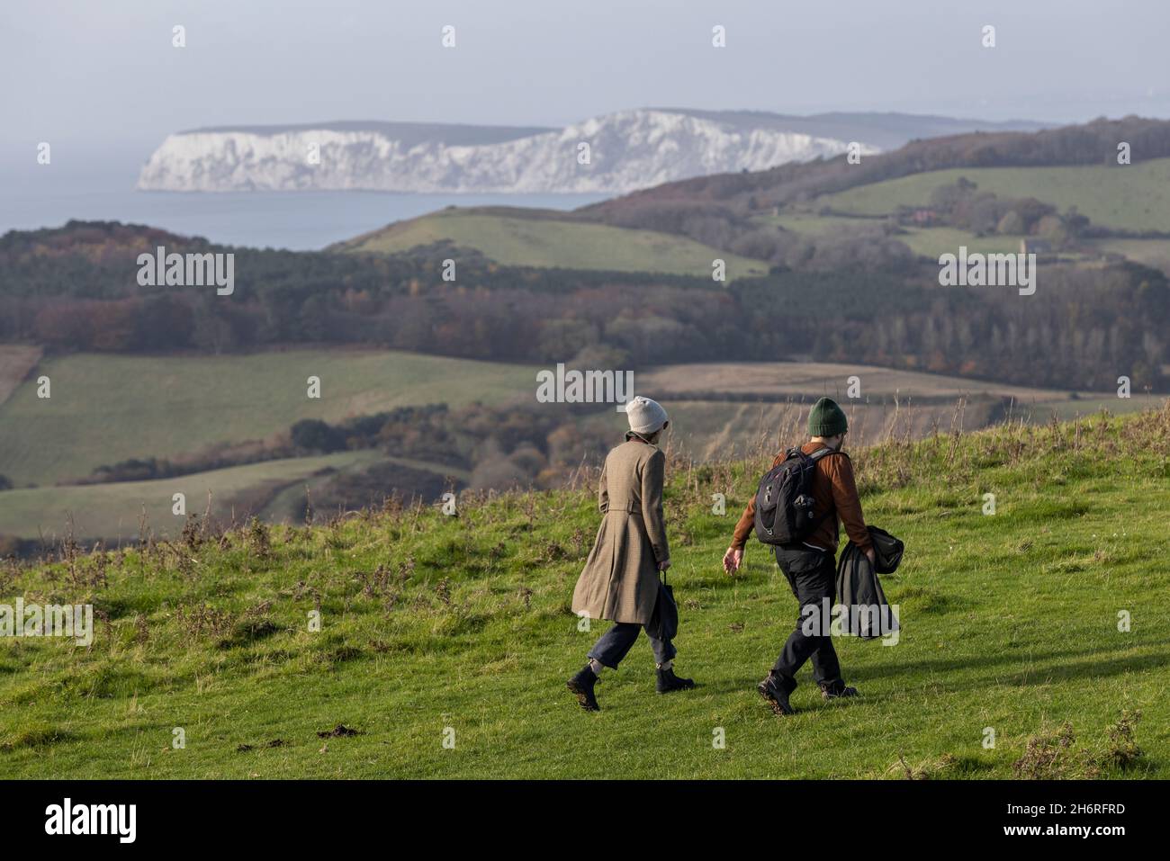 Ein Paar, das über die Mottistone Downs mit Blick auf die Kreidefelsen an der Küste der Isle of Wight, Südengland, Großbritannien, geht Stockfoto