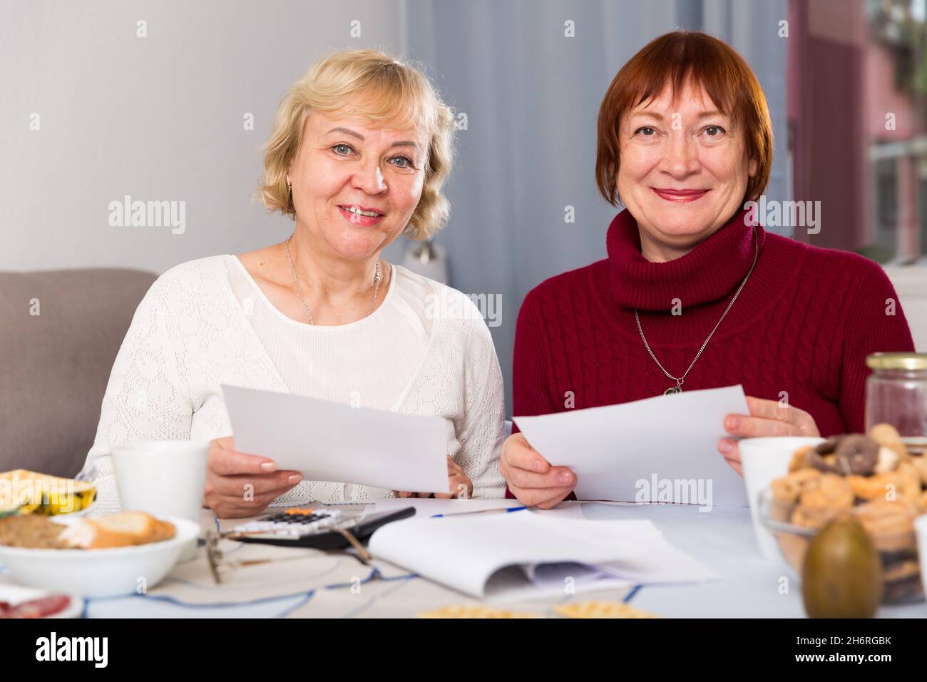 Fröhliche ältere Frauen mit Dokumenten Stockfoto