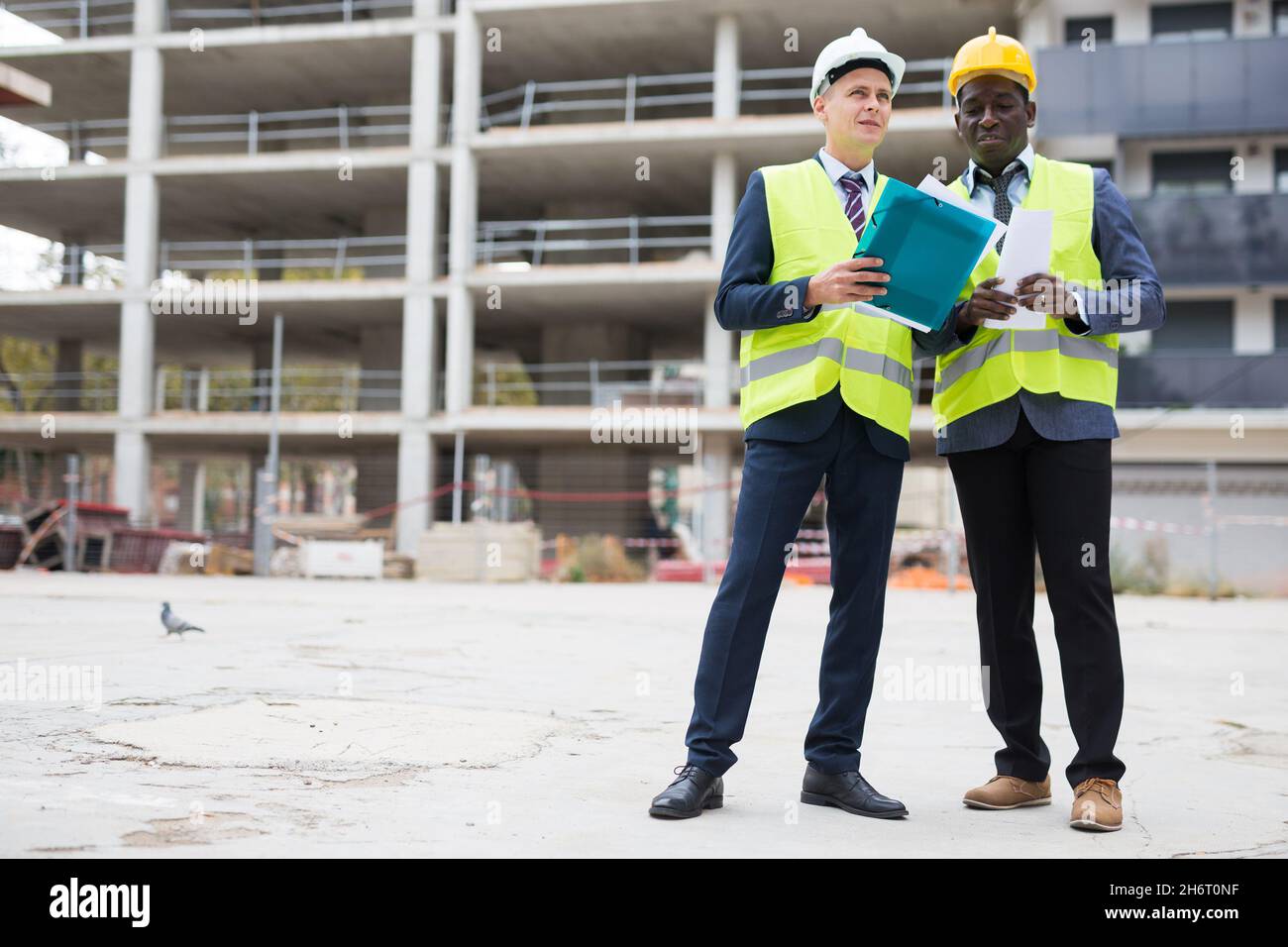 Portrait eines Ingenieurs und Architekten mit Dokumentenmappe auf der Baustelle Stockfoto