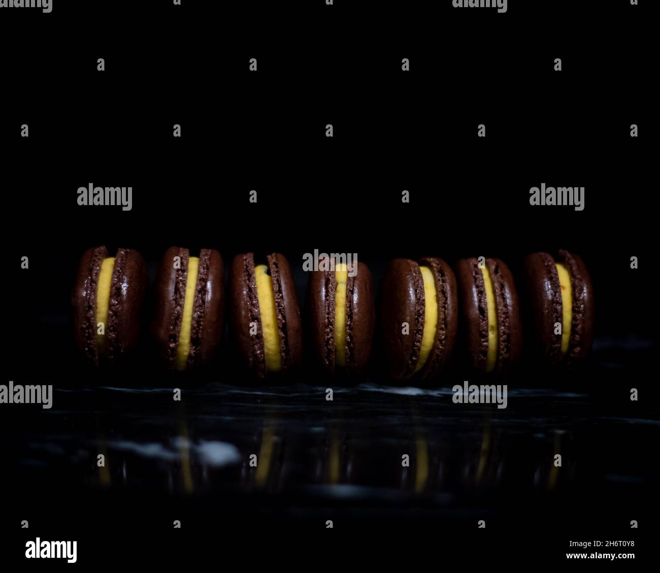 Passionsfrucht-Macarons auf schwarzem Marmor Stockfoto