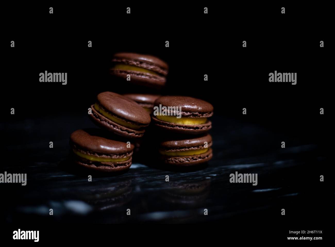 Passionsfrucht-Macarons auf schwarzem Marmor Stockfoto