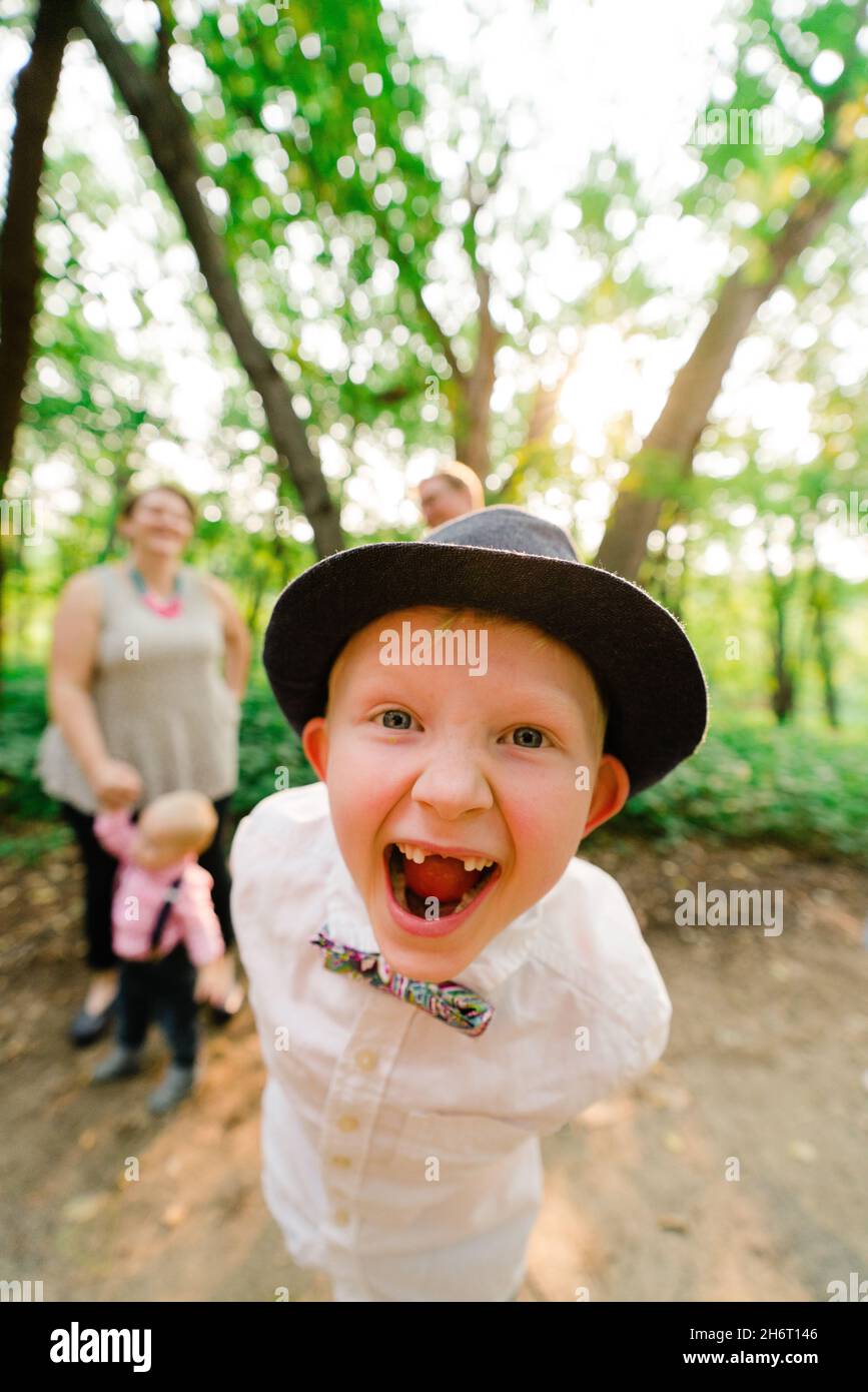 Nahaufnahme eines Jungen, der mit seiner Familie im Hintergrund lachend ist Stockfoto