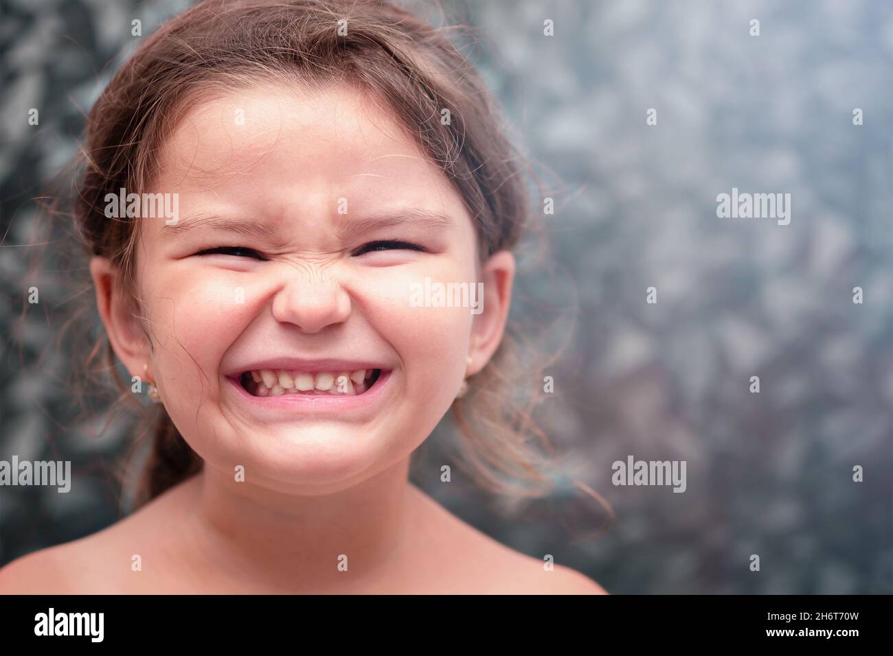 Kind lächelt und zeigt Zähne. Mädchen putzt sich die Zähne im Badezimmer Stockfoto