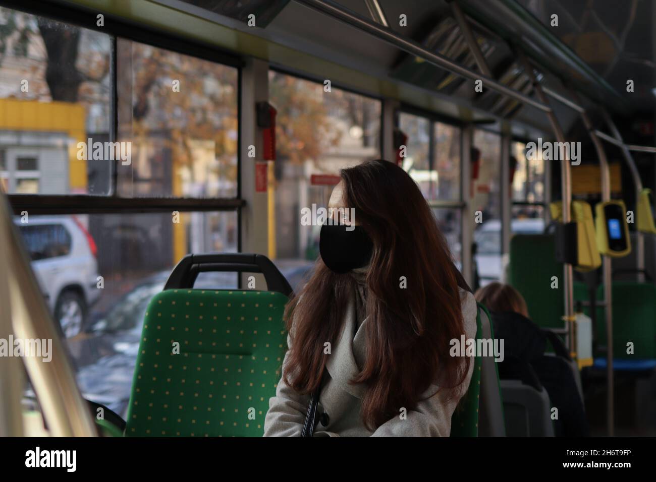 Junge europäische Passagierin mit Gesichtsmaske, wenn sie in der Großstadt Covid19 Outbreak unterwegs ist. Städtetrip im Zusammenhang mit einer kovidierten Pandemie Stockfoto