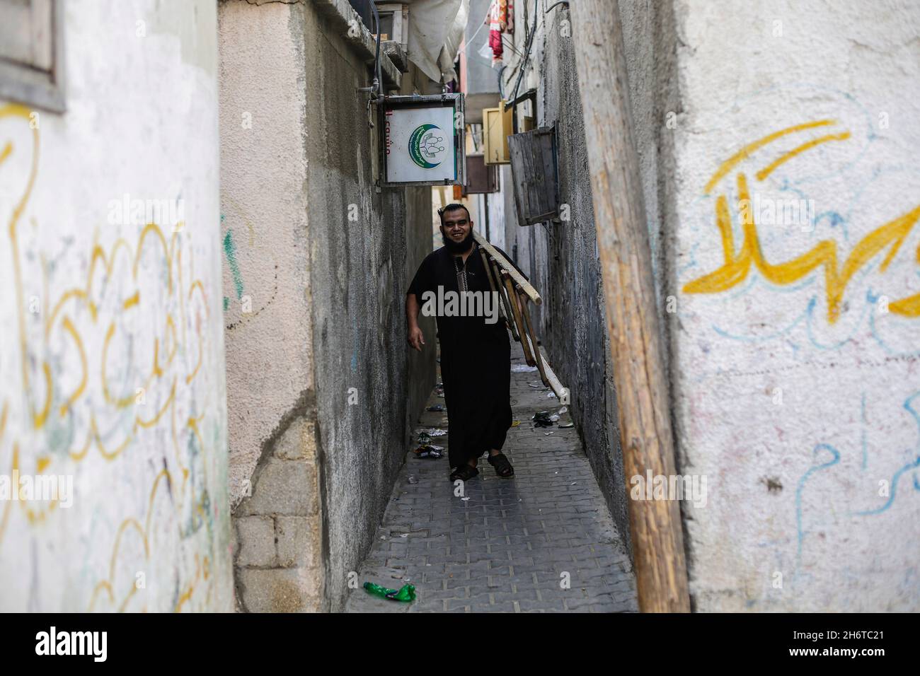 Gaza-Stadt, Palästina. November 2021. Ein Palästinenser, der eine Leiter trägt, geht durch die Gassen des Flüchtlingslagers Jabalia. Kredit: SOPA Images Limited/Alamy Live Nachrichten Stockfoto