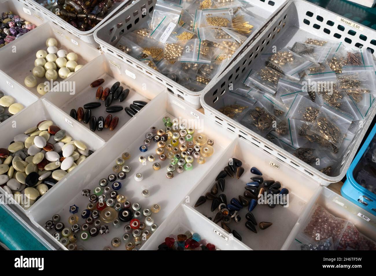 Knöpfe in allen Formen, Materialien, Größen und Farben in Kunststoffboxen mit Preisschildern in einem Marktstand Stockfoto