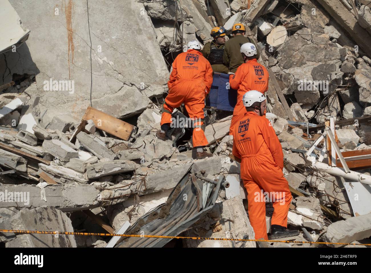 Israelische Soldaten der Rettungseinheit des Home Front Command und Mitglieder des Zaka Disaster Victim Identification Teams laufen durch die Trümmer eines eingestürzten Gebäudes, während sie am 16. November 2021 in Tel Aviv, Israel, an einer Such- und Rettungsübung an einem großen Abrissplatz teilnehmen. Die Home Front-Übung simulierte Such- und Rettungsaktionen, die sich auf Szenarien vorbereiten, die Gebäude zerstören und Bürger aufgrund eines schweren Erdbebens oder massiver Raketeneinschläge einfangen könnten. Stockfoto