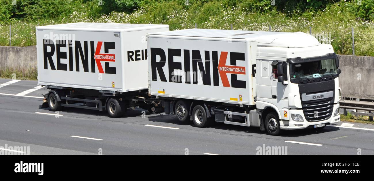Linksverkehr deutsches europäisches internationales Speditionslogo auf weißem lkw-LKW-LKW-LKW und Fahrer-Anhängerkupplung auf der britischen Autobahn England Stockfoto