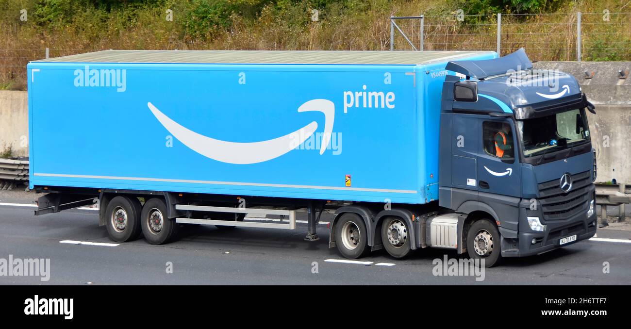 Seite & Vorderansicht des grauen lkw-LKW-LKW blau Amazon Supply Chain  artikulierter Lieferanhänger Fahrer & Logo Marke Werbung Fahren auf der  britischen Autobahn Stockfotografie - Alamy
