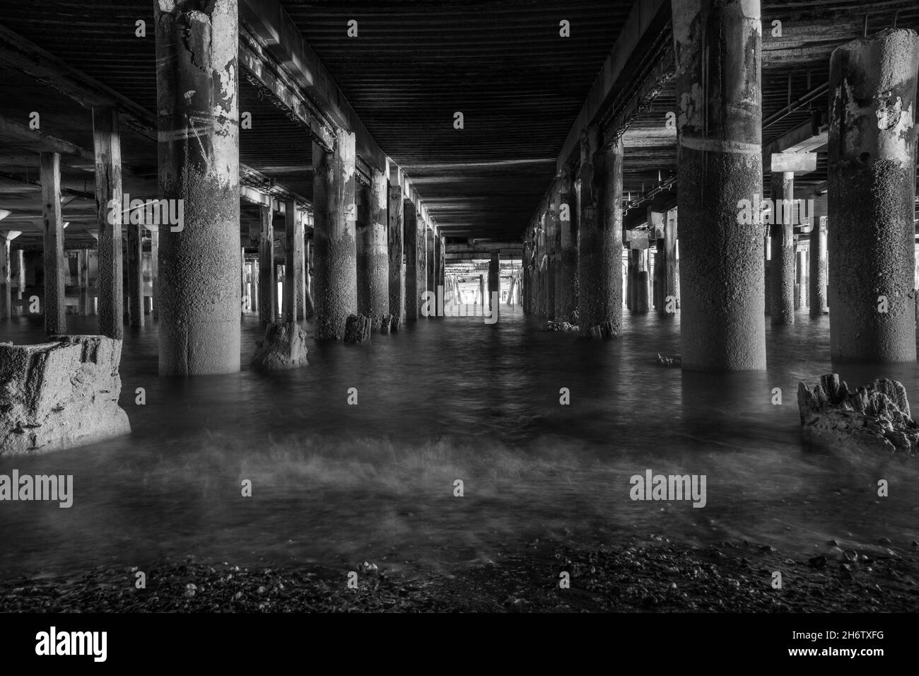 Der Fluss der Gezeiten, die um die verkrusteten Rungen, die Clacton Pier, Essex UK unterstützen, schlagen, Oktober 2021. Stockfoto