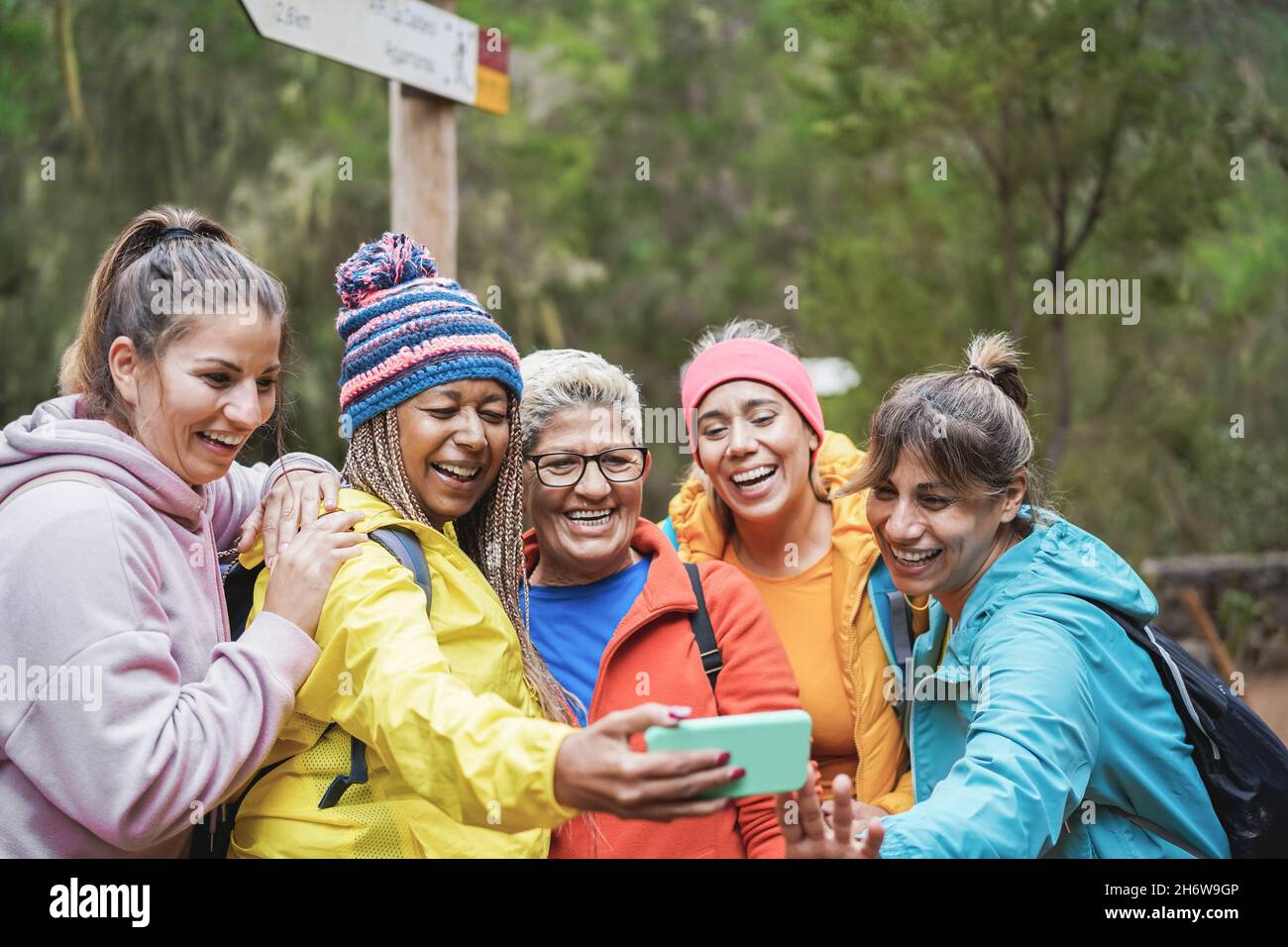 Multirassische Freundinnen, die Spaß beim Selfie haben, während des Trekkingtages in den Wald - Fokus auf afrikanisches Frauengesicht Stockfoto