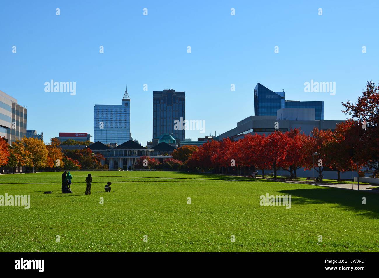 Die Skyline erhebt sich über dem Rasen zwischen Regierungsgebäuden in der Halifax Mall in Raleigh, NC. Stockfoto