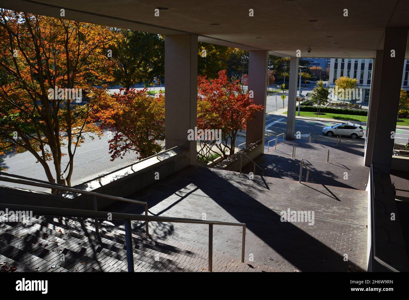 Die Sonne wirft lange Schatten in einem Treppenhaus unter einem Regierungsgebäude auf dem Halifax Mall Complex in Raleigh, NC. Stockfoto