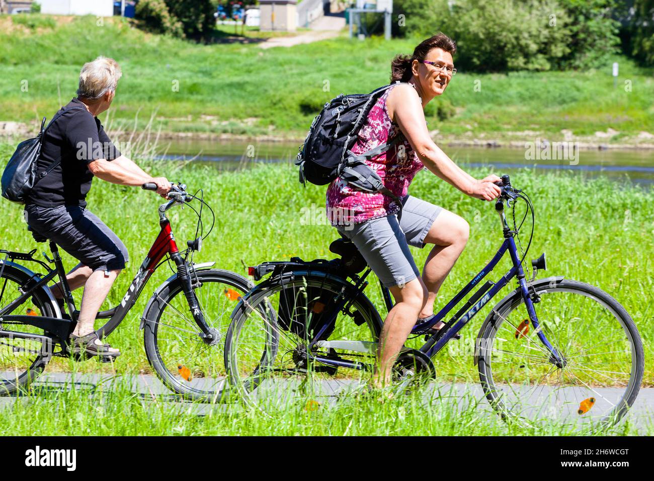 Zwei ältere Frauen Fahrrad fahren entlang der Elbe Deutschland Sachsen Outdoor gesunde Lebensweise Stockfoto