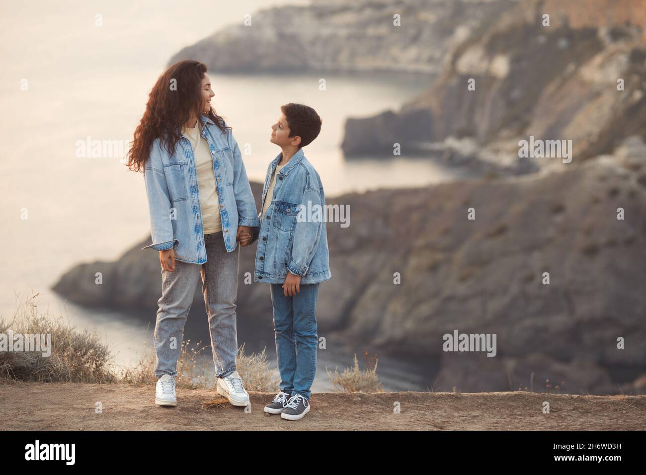 Lifestyle-Foto von glücklicher Mutter und jugendlicher Junge halten den Griff zusammen. Spanische Touristen Mutter und Kind im Urlaub. Stockfoto