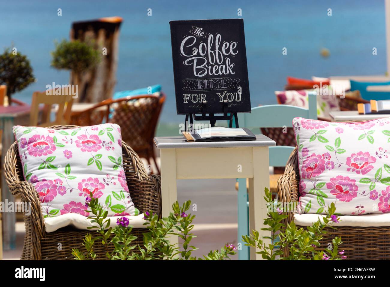 Kaffeepause am Strand, Blick auf das griechische Café, Blick auf das Meer, Kreidetafel-Menü Stockfoto