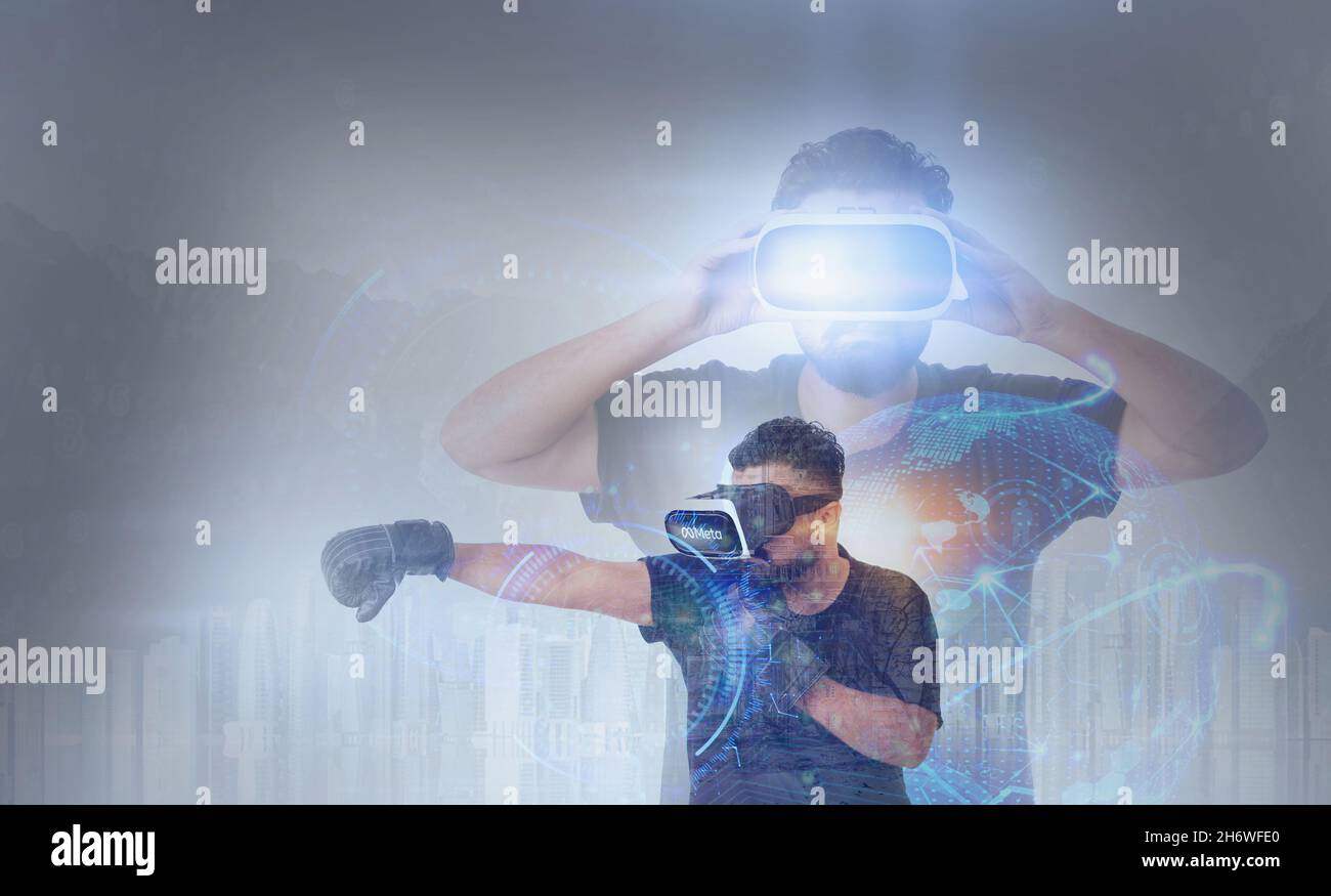 Guy trägt Virtual Reality Goggles Spielen Boxsport in Einem Metaverse - Meta auf den Googles geschrieben Stockfoto