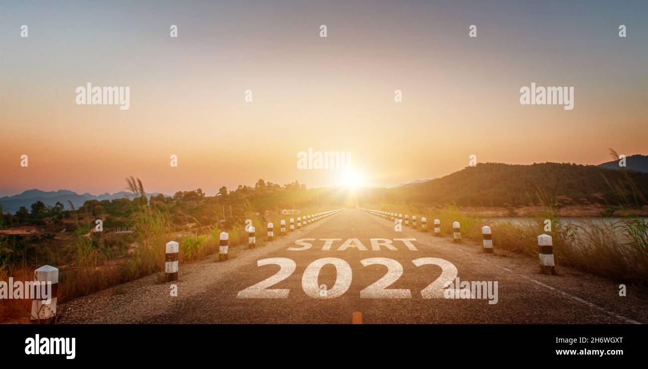 Neues Jahr 2022 geschrieben auf Autobahn Straße. Leere Asphaltstraße und schöner Sonnenaufgang Himmel Hintergrund. Ziel- und Challenge-Konzept für Vision 2022. Stockfoto