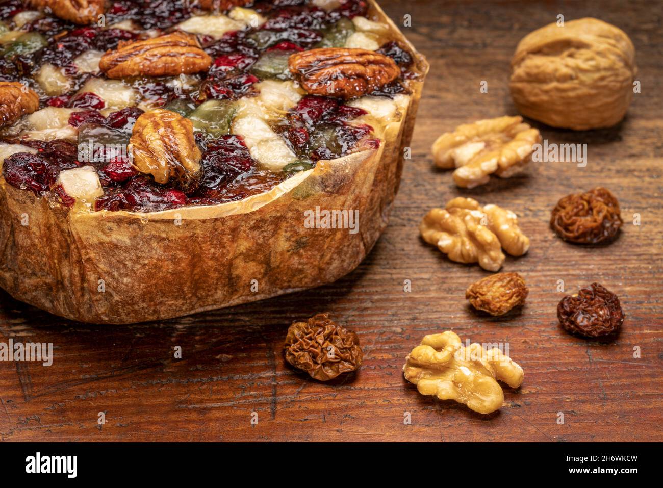 Urlaub Rum Kuchen mit Pekannüssen, Kirsche, Walnüssen und Goldbeere auf einem grunge, verwitterten Holz Stockfoto