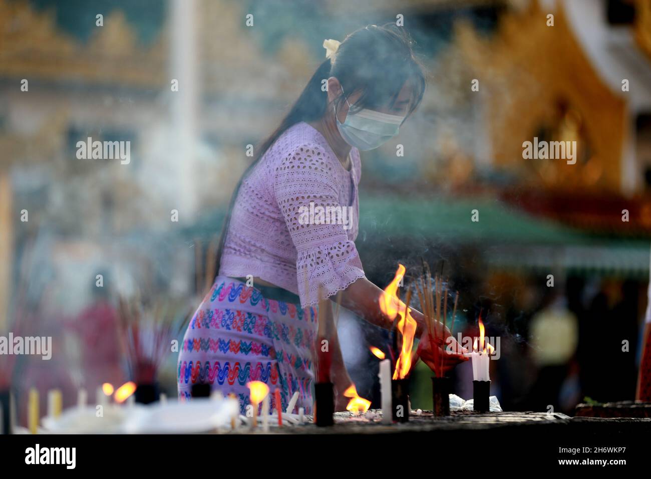 Yangon, Myanmar. November 2021. Eine Frau zündet während des traditionellen Tazaungdaing Festivals in der Shwedagon Pagode in Yangon, Myanmar, am 18. November 2021 Kerzen an. Das Tazaungdaing Festival, auch bekannt als das Festival of Lights, fällt in den achten Monat des traditionellen myanmarischen Kalenders. Es wird als Nationalfeiertag in Myanmar gefeiert. Quelle: U Aung/Xinhua/Alamy Live News Stockfoto