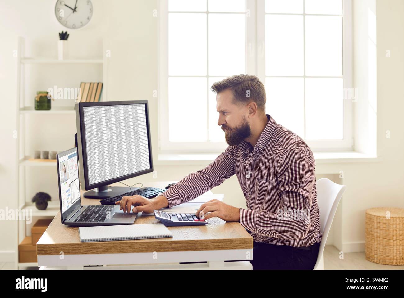 Finanzbuchhalter mit Computern und Taschenrechner während der Arbeit am Schreibtisch im Büro Stockfoto