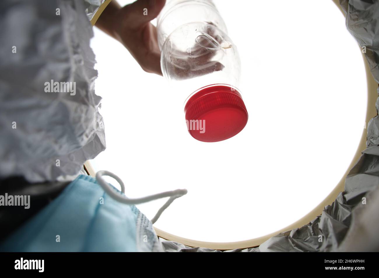 Eine leere Plastikflasche wird in den Müll geworfen.Blick vom Eimer Stockfoto