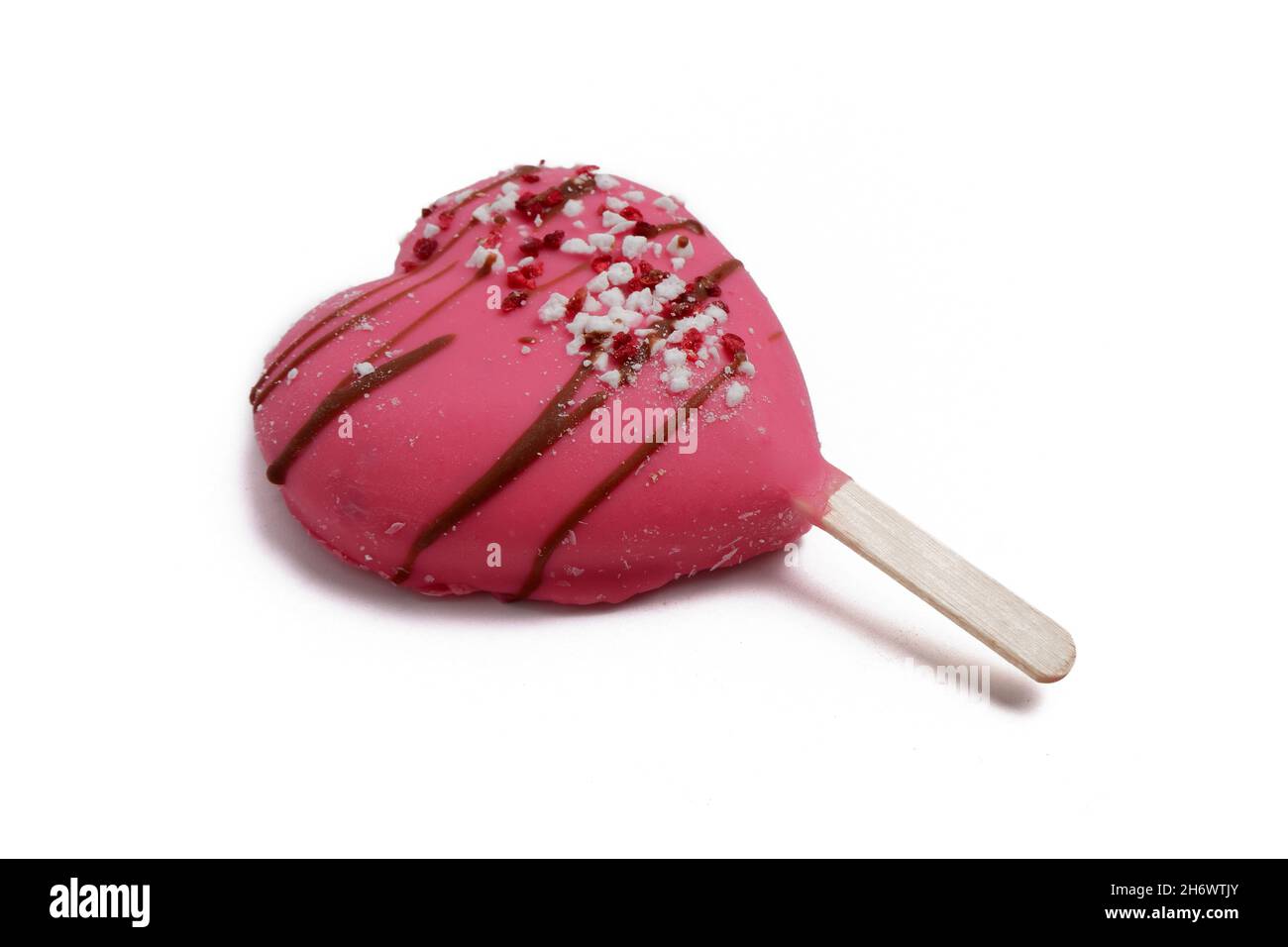 Rosa Eiscreme auf einem herzförmigen Stock liegt isoliert auf weißem Hintergrund Stockfoto