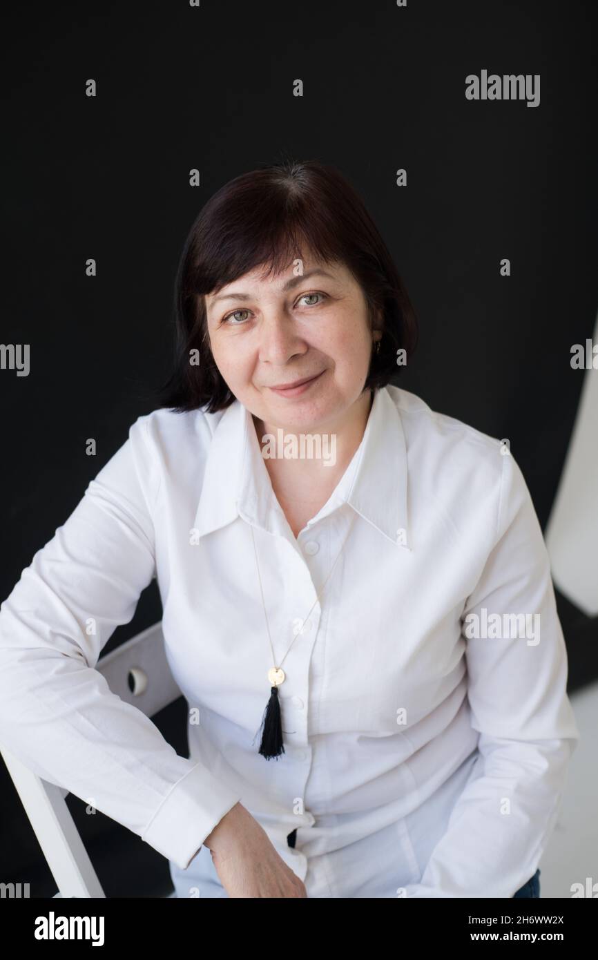 Porträt einer 50-jährigen Frau, mit kurzem Haarschnitt, in einem weißen Hemd und Jeans. Ein moderner und unabhängiger Erwachsener mittleren Alters Stockfoto