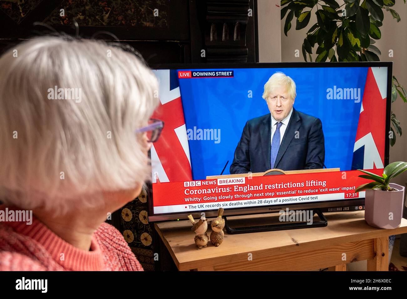 Boris Johnson kündigt im BBC TV an, dass die Beschränkungen von Covid aufgehoben werden sollen; dies wird von einer älteren Frau beobachtet. 12/07/2021. Stockfoto