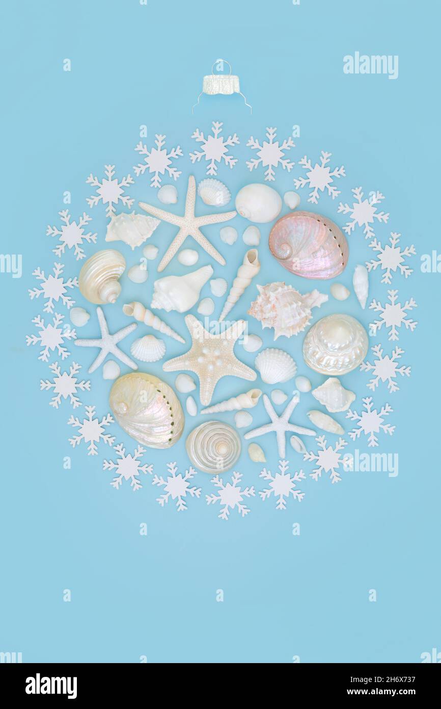 Weihnachten im Sommer abstraktes Kugelkonzept mit Muscheln und Schneeflocken auf blauem Hintergrund. Festliche Dekoration für alternative Weihnachtszeit . Stockfoto