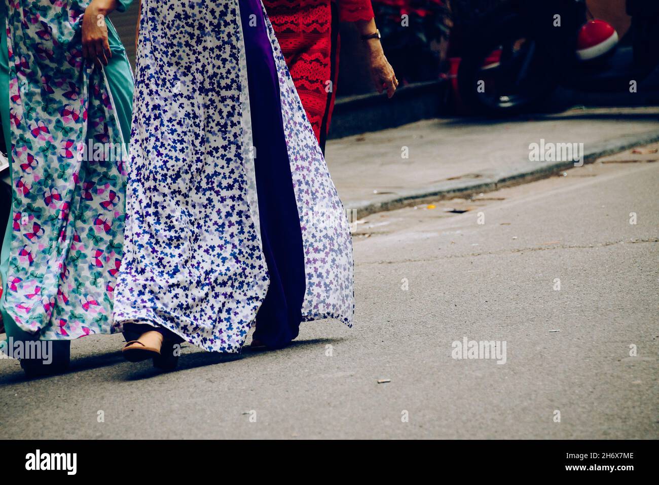 Niedriger Teil der vietnamesischen Frauen, die in traditioneller Kleidung namens AO dai für das Tet Festival in Hanoi, Vietnam, auf der Straße spazieren gehen Stockfoto