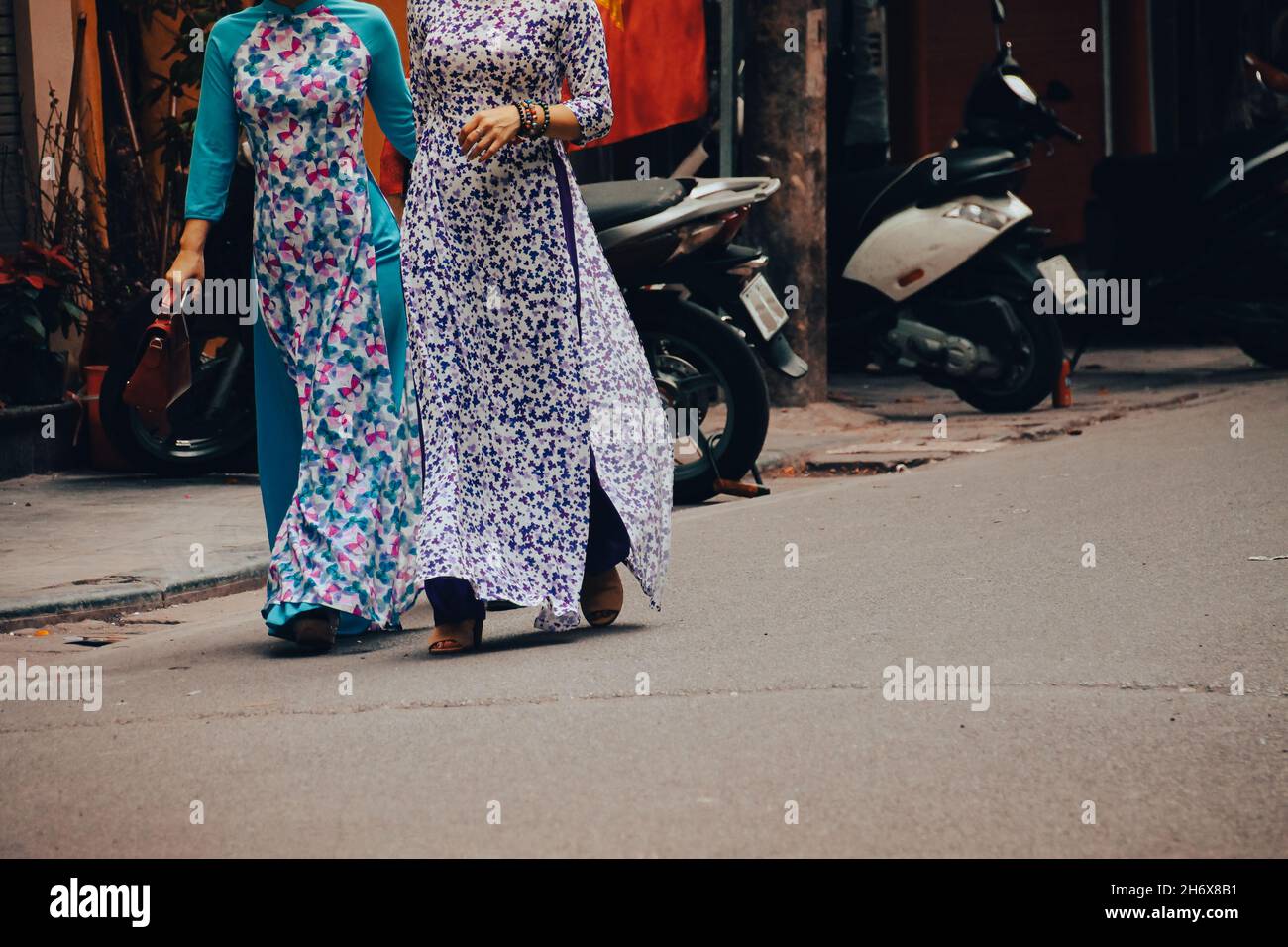 Niedriger Teil der vietnamesischen Frauen, die in traditioneller Kleidung namens AO dai für das Tet Festival in Hanoi, Vietnam, auf der Straße spazieren gehen Stockfoto