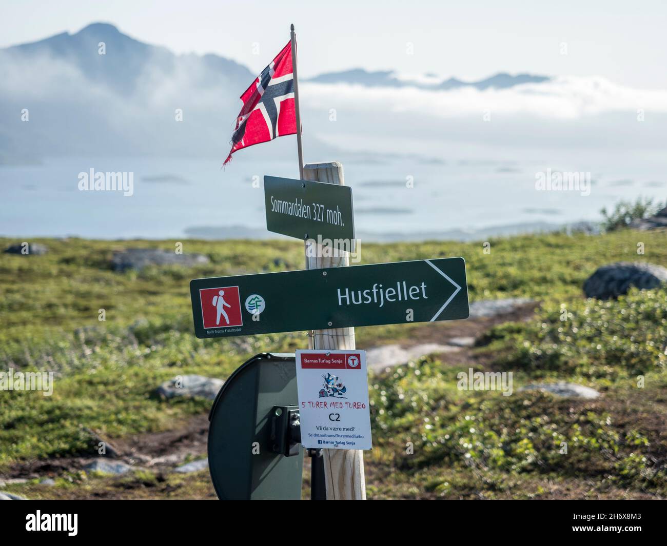 Wegweiser auf dem Weg nach Husfjellet, Wolken bedecken Berge und Fjord Bergsfjorden, Senja Insel, Norwegen Stockfoto