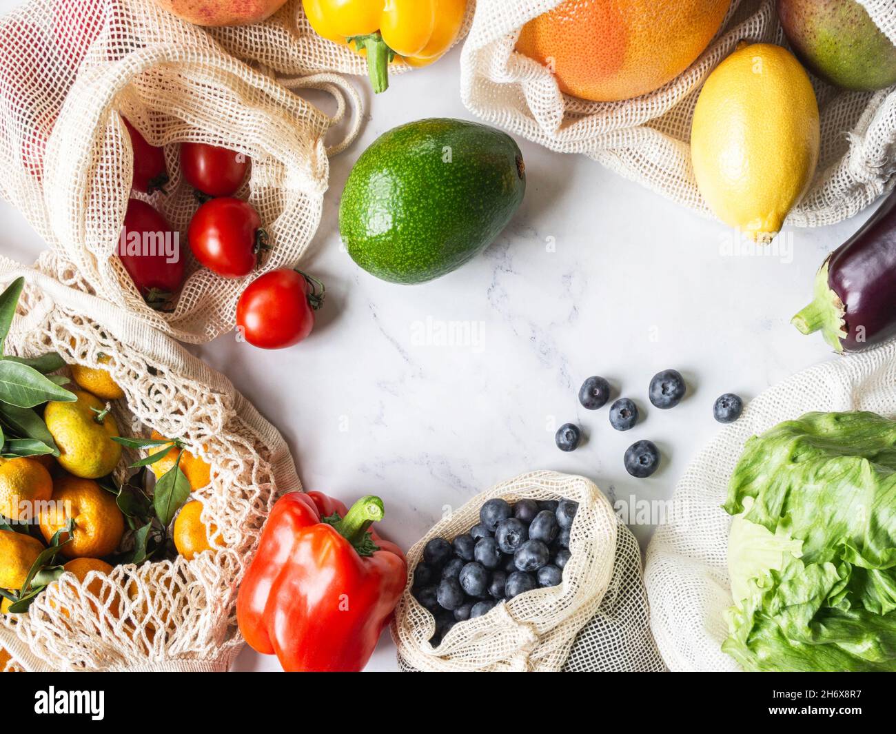 Frisches Gemüse und Obst in Öko-Baumwollbeuteln auf dem Tisch in der Küche. Zero Waste Shopping-Konzept. Draufsicht. Speicherplatz kopieren. Flach liegend Stockfoto