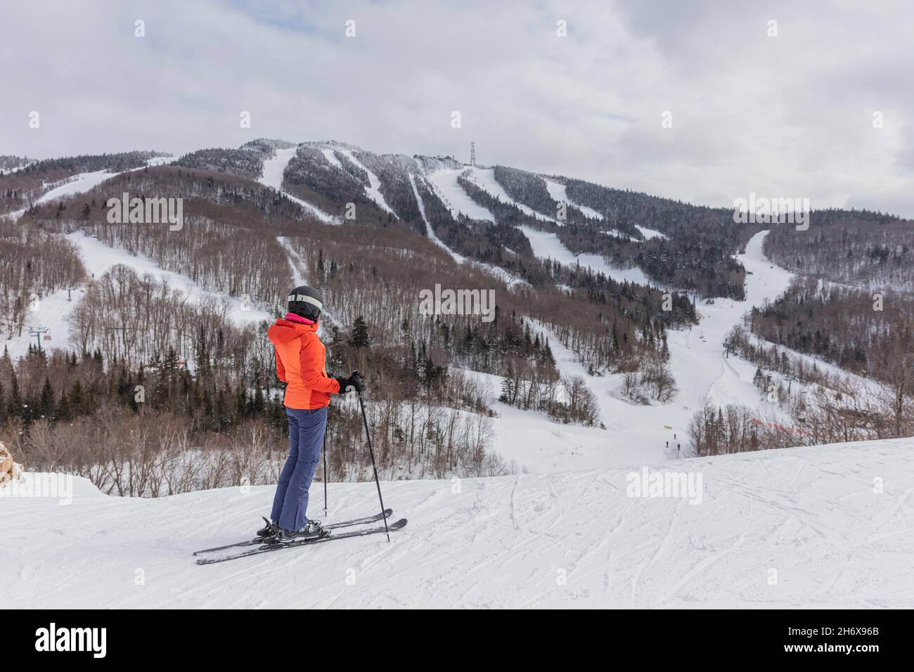 Skifahrerin. Alpine Ski - Skifahrer mit Blick auf die Berge gegen schneebedeckte Bäume und Ski im Winter. Mont Tremblant, Quebec, Kanada. Stockfoto