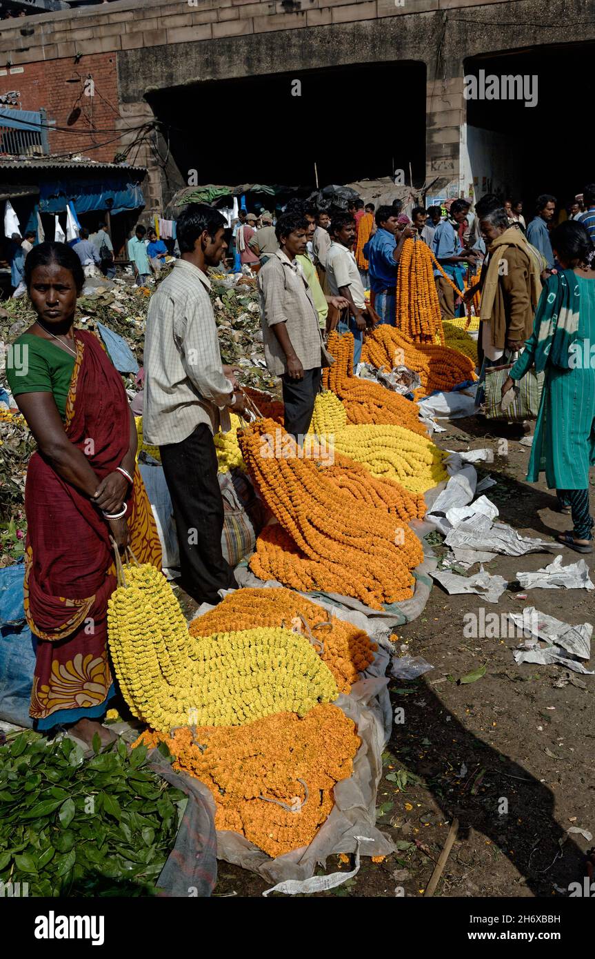 Händler auf dem Howrah Blumenmarkt mit Ringelblumen und Puja-Angeboten, Kalkutta, Indien Stockfoto