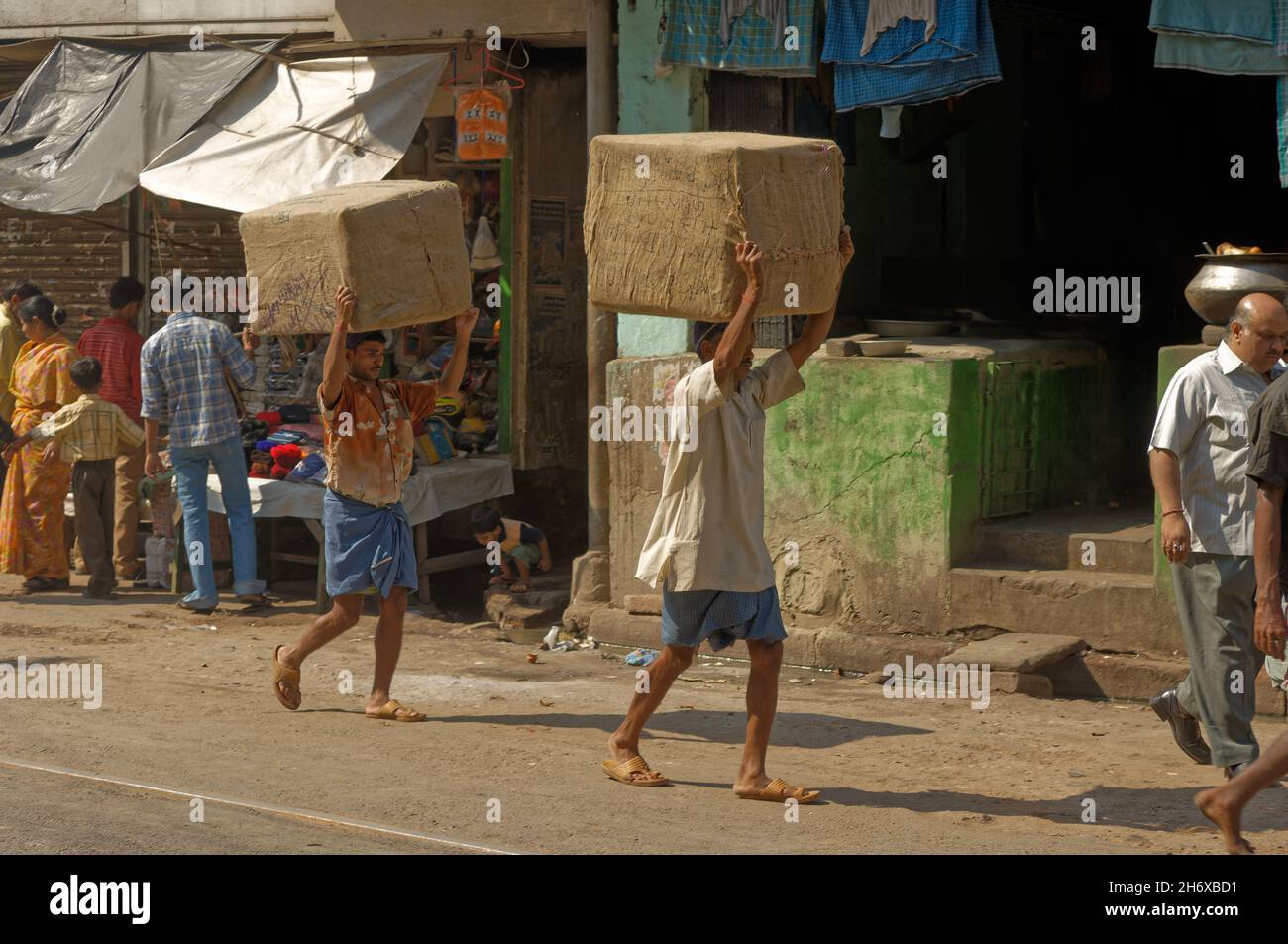 Manuelle Labou, zwei Menr, die Waren in Kisten transportieren, indem sie ihre Köpfe in einer Seitenstraße von Kalkutta, Indien, tragen Stockfoto