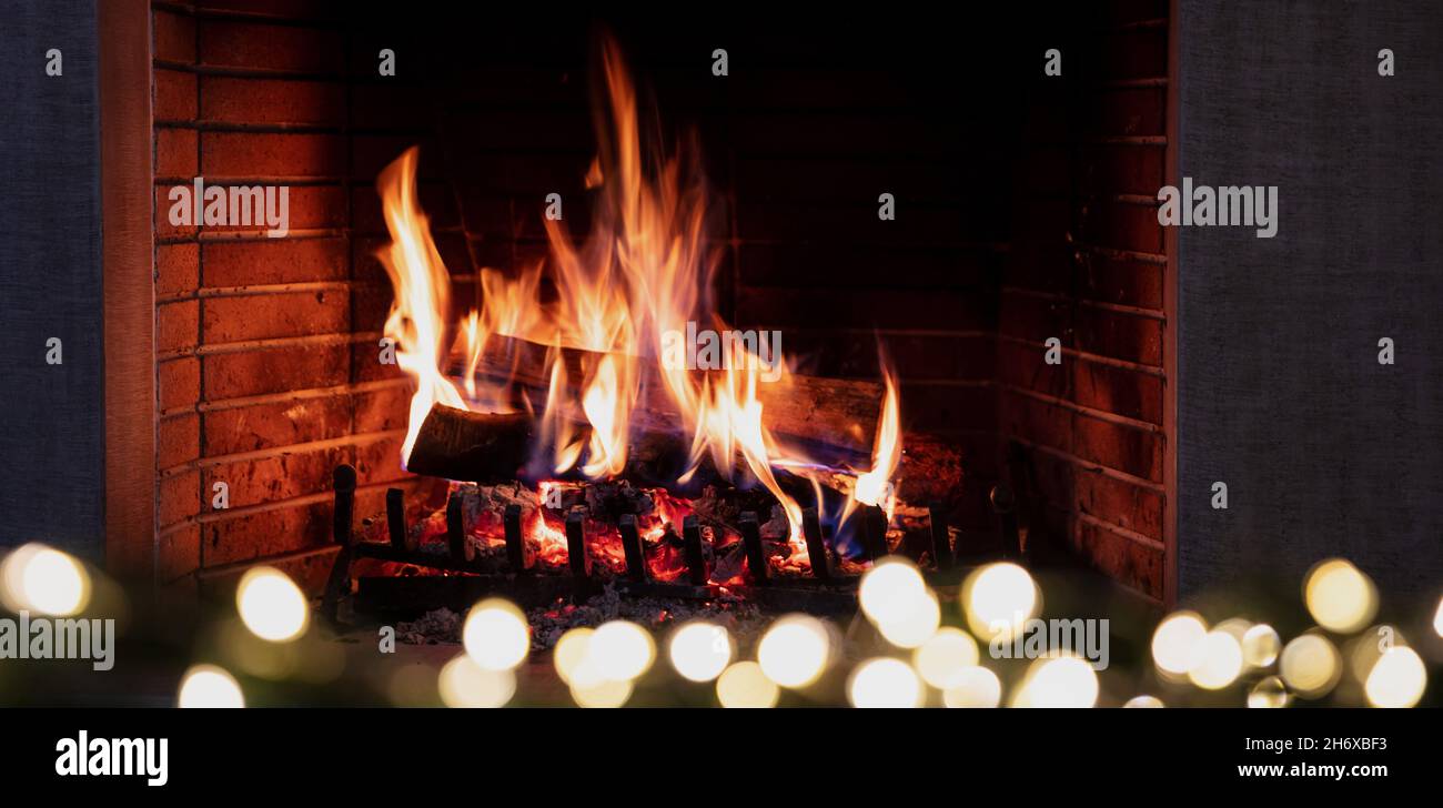 Weihnachtslichter und brennender Kamin, Lagerfeuer-Flammen und festliche Dekoration. Gemütliches Wohnzimmer Interieur, Winterurlaub Entspannung und warme hom Stockfoto