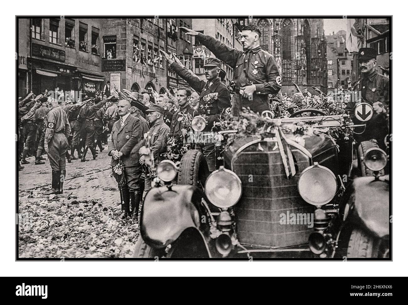 Adolf Hitler in SA-Uniform mit Hakenkreuz-Armband, in einer Blume stehend oben bedeckter Mercedes-Motorwagen begrüßt die SA-Truppen bei einer Nürnberger Nazi-Deutschland-Parade der 1930er Jahre Julius Streicher berüchtigte antisemitische Nazi-Soldaten stehen auch vor einer Gruppe vor Adolf Hitler Stockfoto