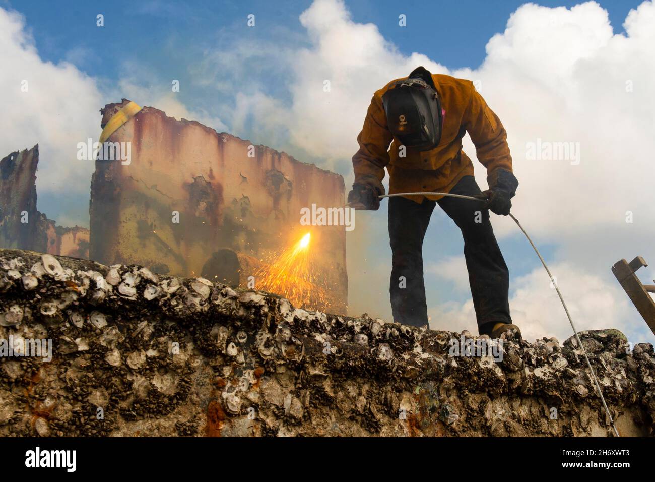 Guam. November 2021. Navy Diver 2. Klasse Kolby Konopacky, von Stevens Point, Wis., angeschlossen an die Marine Mobile Diving and Salvage Unit (MDSU) 1, verwendet ein Keri-Kabel, um verlassene verlassene Schiffe im Guam Harbour of Refuge zu zerlegen. Konopacky ist Teil eines US-Navy-Teams von Commander, Logistics Group Western Pacific, Task Force 73, Und die Task Force 75, die in Zusammenarbeit mit den US-Küstenwachen, Mikronesien/Sektor Guam, der Guam Environmental Protection Agency, dem Bureau of Statistics and Plans, dem Landwirtschaftsministerium von Guam, Guam Power AUT, mit der Entfernung verlassene, verlassene Schiffe im Hafen begann Stockfoto