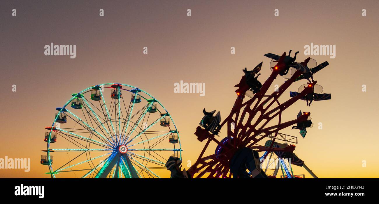 Jahrmarkt, Fahrt auf dem Festgelände bei Sonnenuntergang, Abenddämmerung Stockfoto