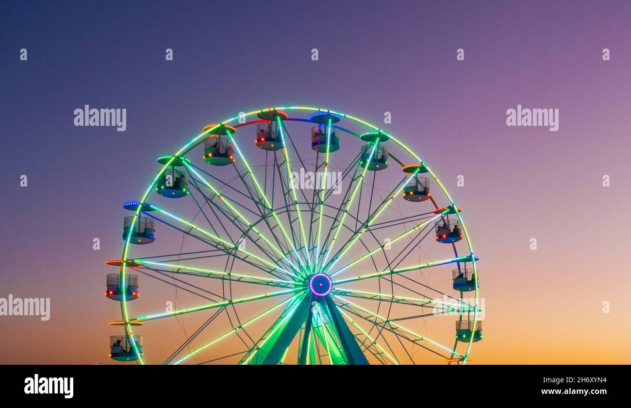 Jahrmarkt, Fahrt auf dem Festgelände bei Sonnenuntergang, Abenddämmerung Stockfoto