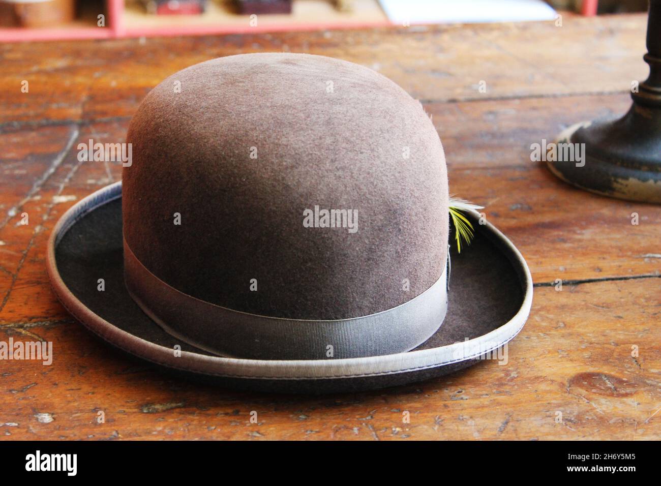 Nahaufnahme eines antiken Melone-Hutes mit einer Feder im Hutband. Stockfoto