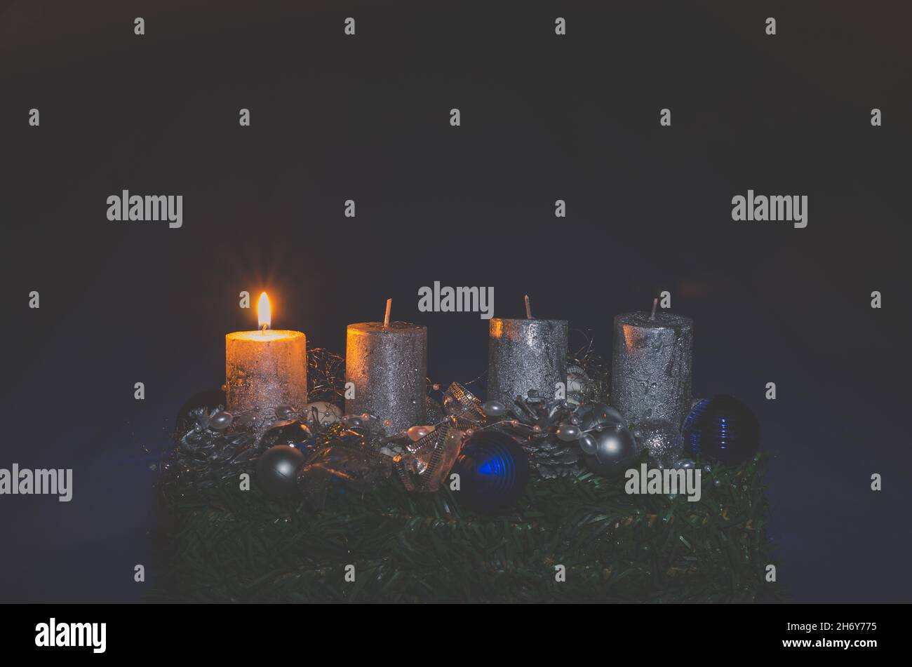 1. adventkonzept mit einer glühenden brennenden Kerze Stockfoto