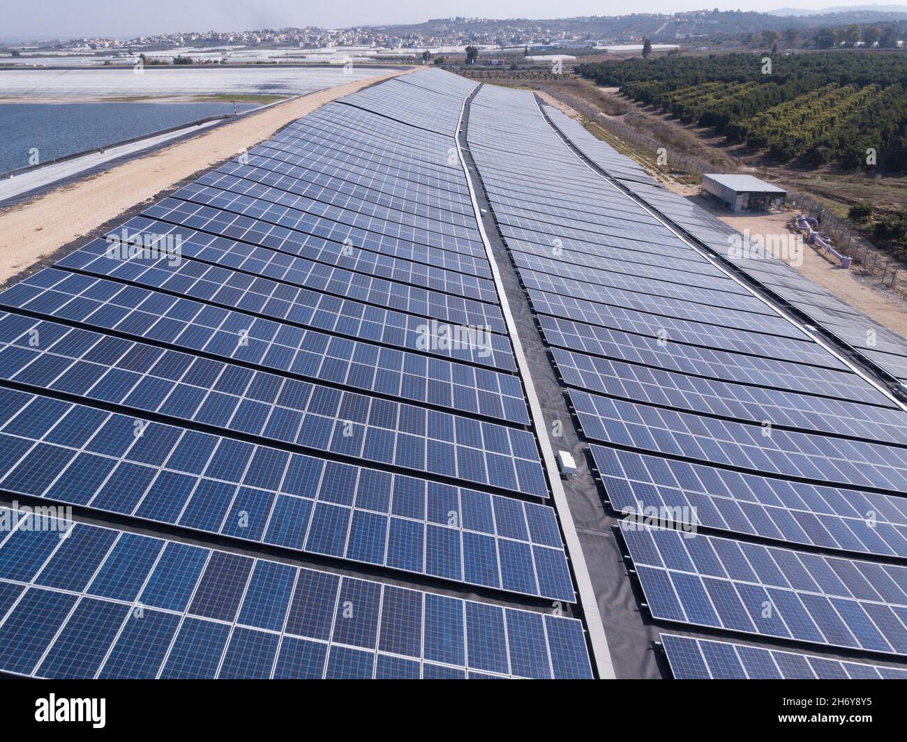 Sonnenkollektoren, die auf einer Wasserreservoirbank installiert sind. Stockfoto
