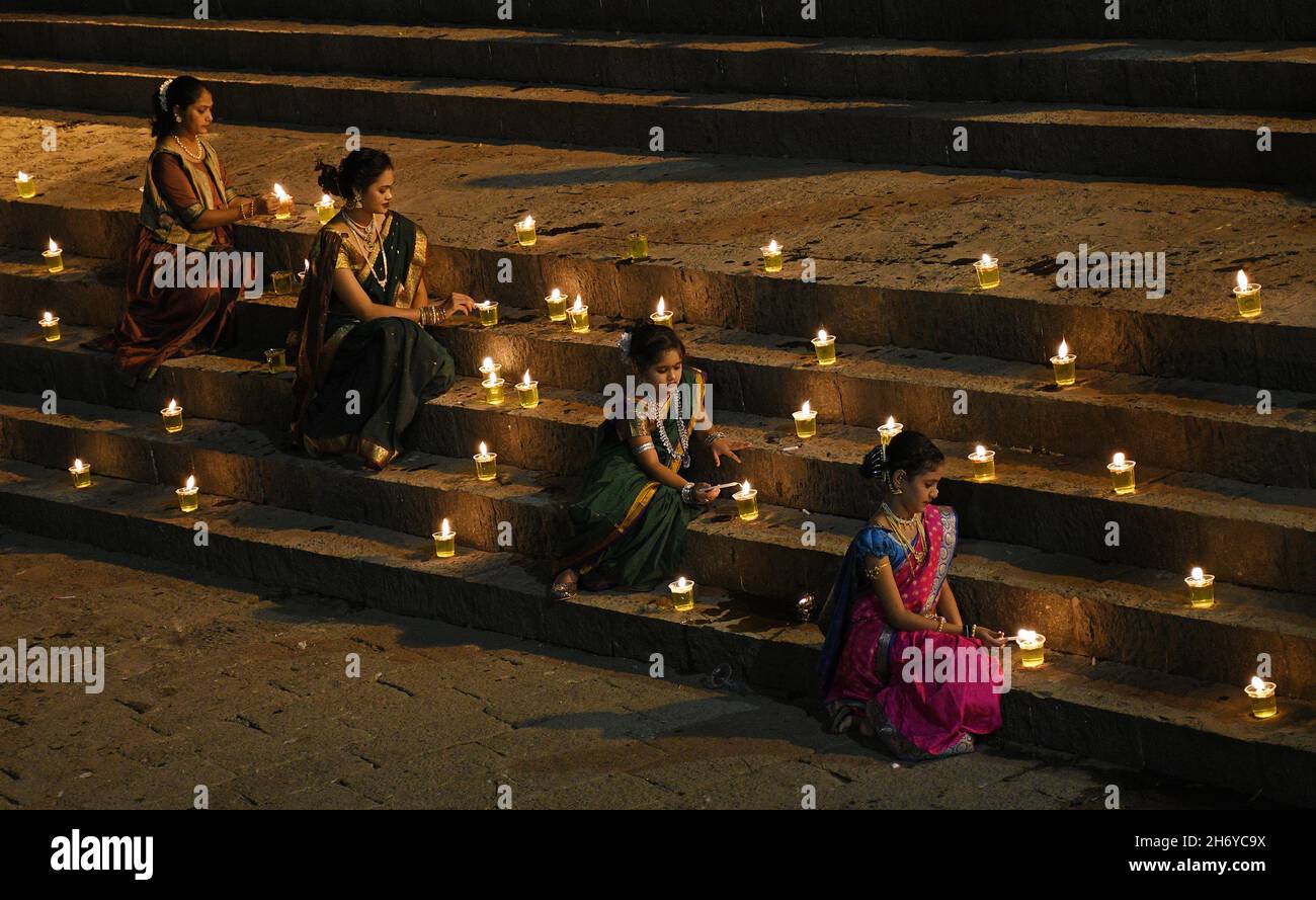 Mumbai, Indien. November 2021. Frauen und Kinder, die in einem traditionellen Saree gekleidet waren, sahen während der Feier eine Diya (irdene Lampe) im Banganga-Wasserbehälter anzünden. Dev Diwali wird von Hindus durch das Anzünden von Diyas (irdenen Lampen) gefeiert. Es gedenkt auch Lord Shivas Sieg über die Asuras (Dämonen). Kredit: SOPA Images Limited/Alamy Live Nachrichten Stockfoto
