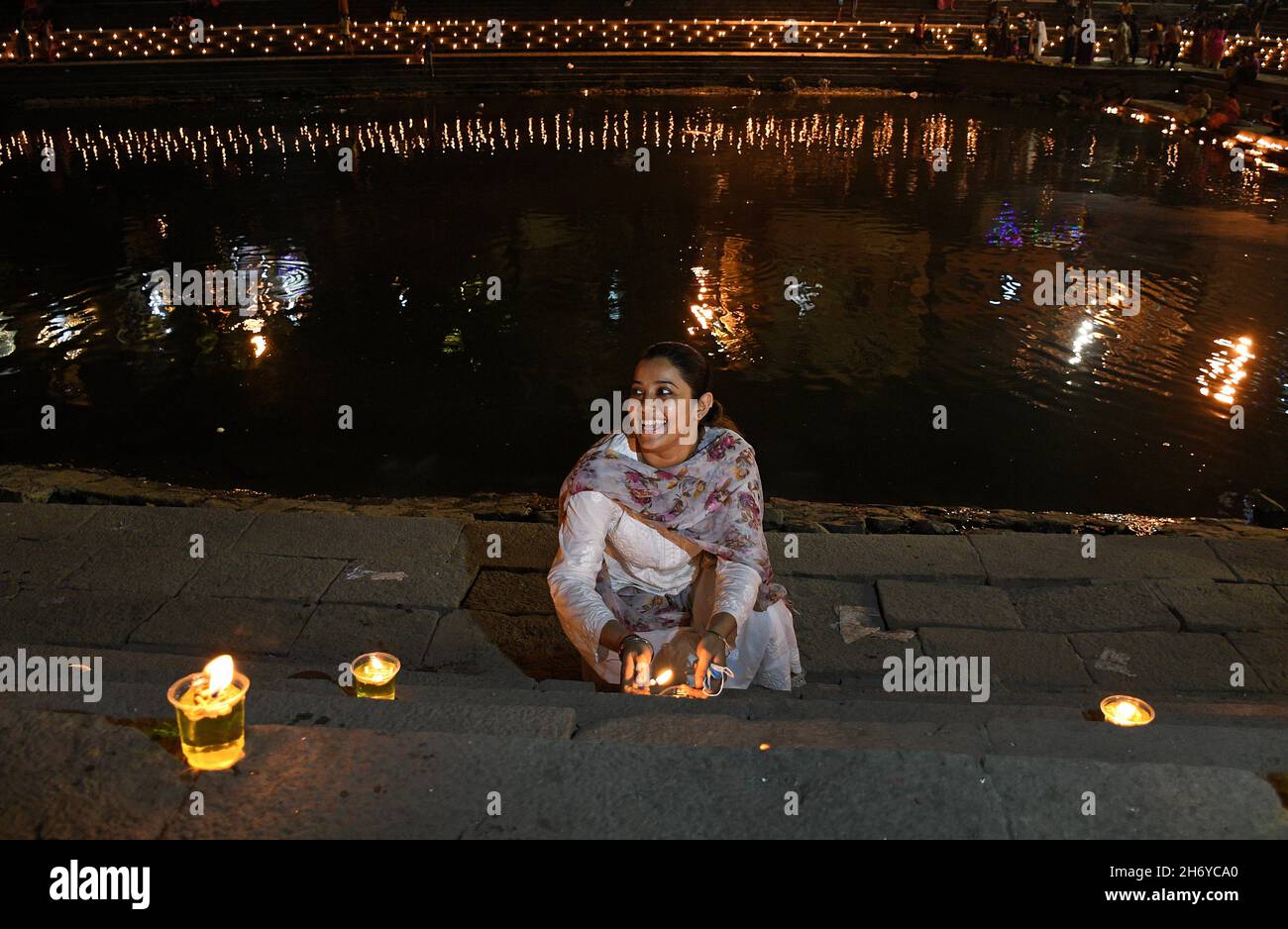 Mumbai, Indien. November 2021. Eine Frau zündet während der Feier eine Diya (irdne Lampe) am Banganga-Wasserbehälter an. Dev Diwali wird von Hindus durch das Anzünden von Diyas (irdenen Lampen) gefeiert. Es gedenkt auch Lord Shivas Sieg über die Asuras (Dämonen). Kredit: SOPA Images Limited/Alamy Live Nachrichten Stockfoto